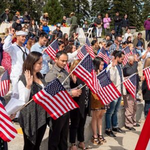 Ceremonia de naturalización en EE.UU. con migrantes jurando lealtad durante su proceso de ciudadanía
